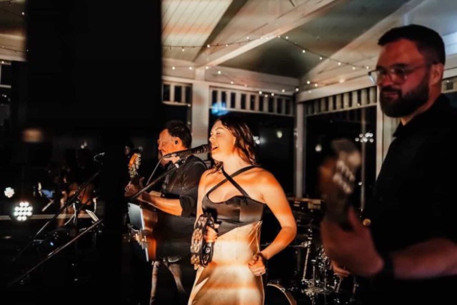 Still Slaps performing live — vocalist with tambourine and bandmates on stage